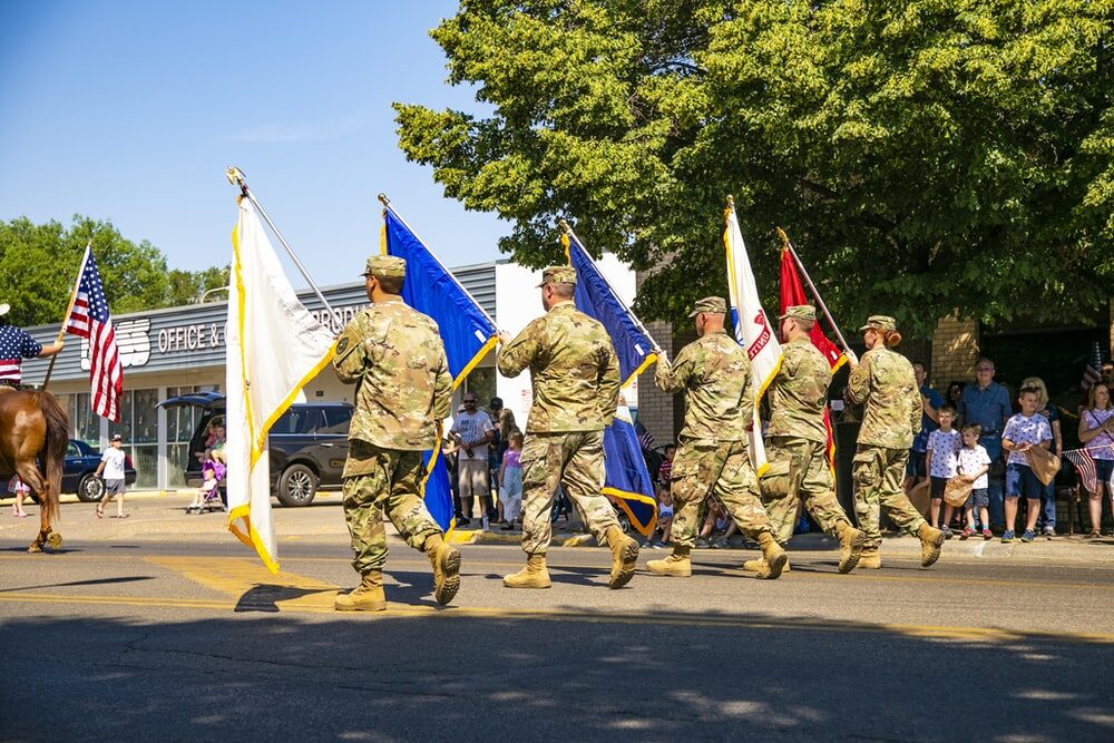 military service members parading with flags