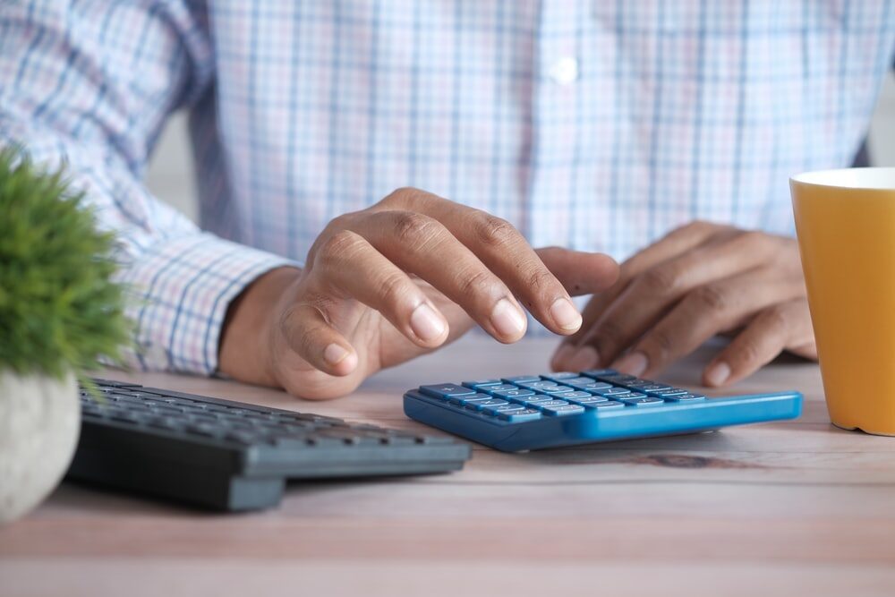  man sitting at a desk using a calculator