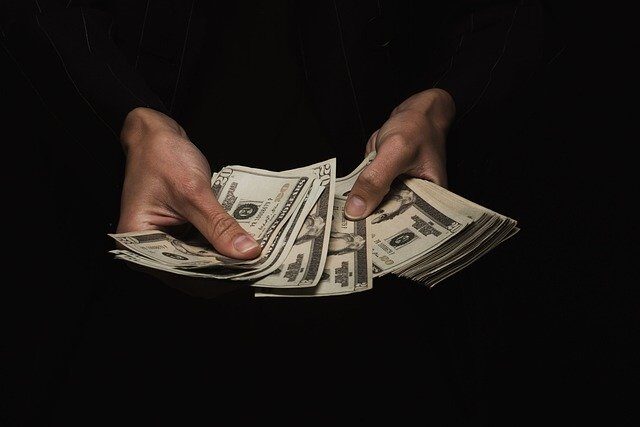 A private money lender counting twenty-dollar note