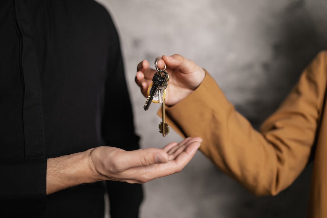 A person handing a set of keys to another person