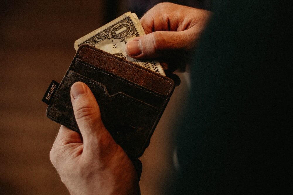A person pulling out cash from a wallet