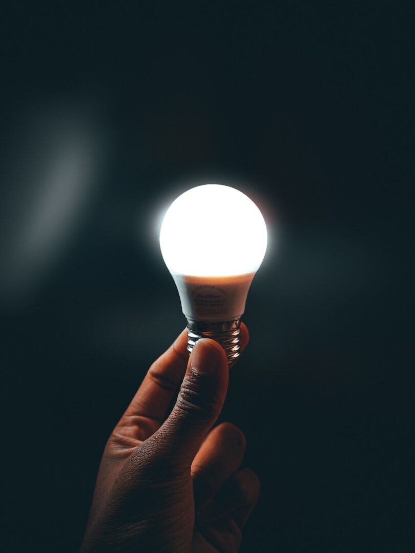 A person holding an LED bulb in their hand