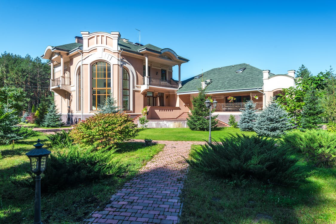 A brick garden pathway surrounding a mansion