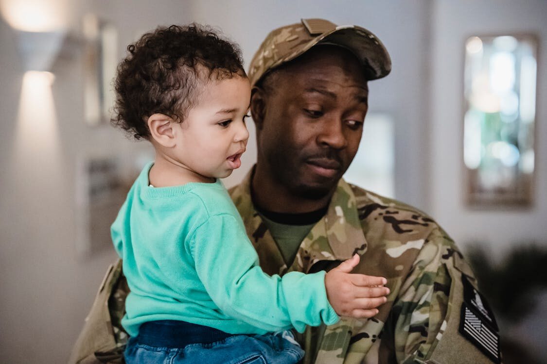 A soldier holding a boy in a home