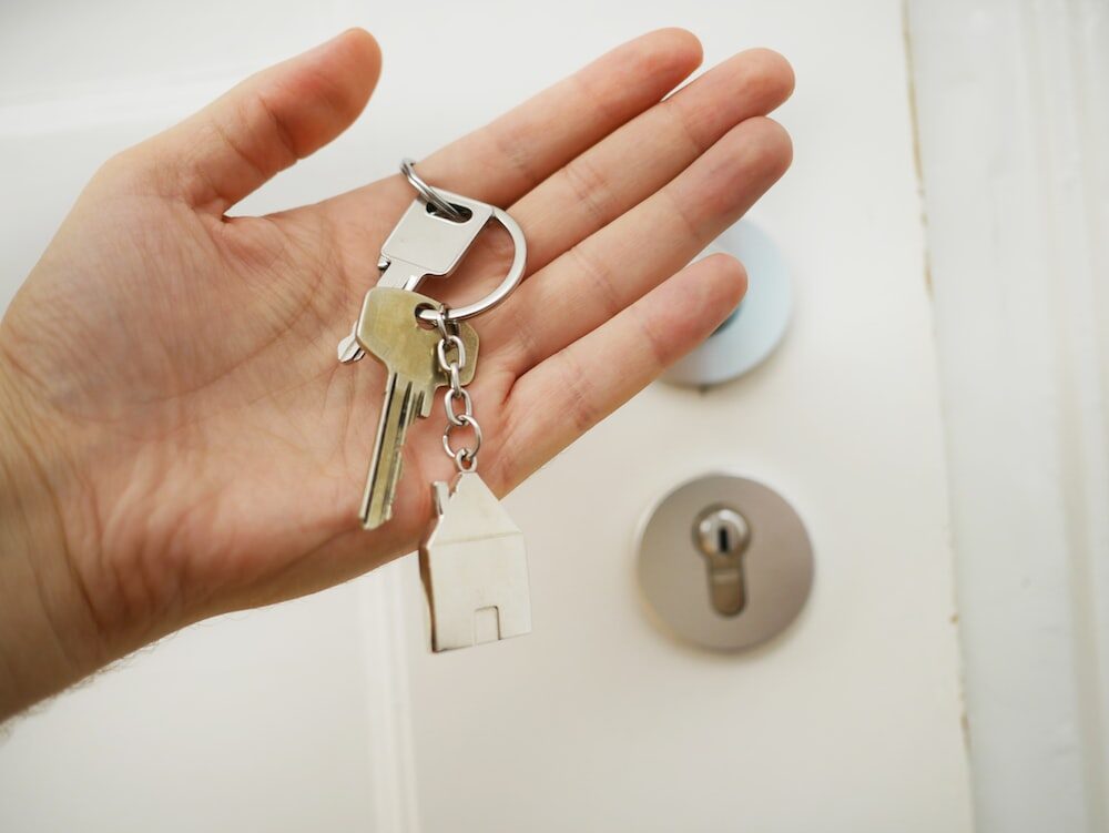 A person holding a house-shaped keychain