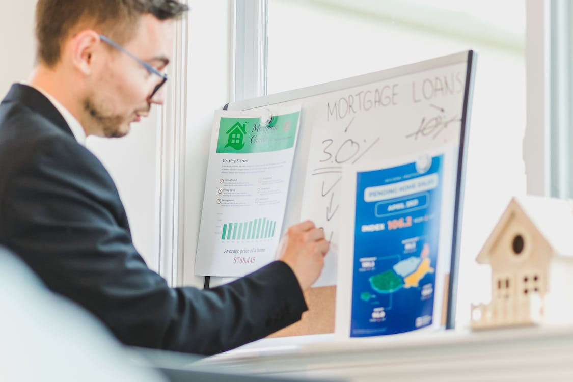 A mortgage broker writing on a whiteboard